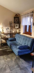 尼萨河畔亚布洛内茨Chata V Lukách的一张蓝色的沙发,位于带床的房间