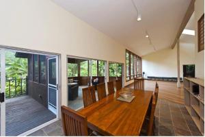 Waipio Valley Botanical Garden的一间带木桌和椅子的用餐室