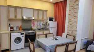 巴库LV Apartments的厨房配有桌子、炉灶和冰箱。