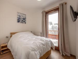 拉普拉涅Appartement La Plagne, 3 pièces, 6 personnes - FR-1-351-93的卧室配有白色的床和窗户。