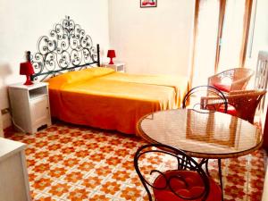 托雷阿马莱Residence Baia degli Sciti的卧室配有一张床和一张桌子及椅子