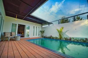 瓦亚纳德Jungle Bay Resorts & Spa的木甲板上设有游泳池的房子