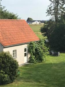 斯劳厄尔瑟Landlig idyl - direkte til golfbane的一座橙色屋顶的房子,在院子里设有长凳