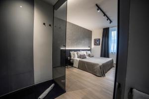 佩斯卡拉Corso 84 Luxury Suites的一间卧室设有一张床和玻璃墙