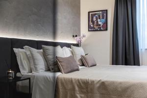 佩斯卡拉Corso 84 Luxury Suites的卧室配有带白色枕头的大床