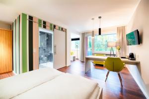柏林卡罗琳彩云之南酒店的一间卧室配有一张床、一张桌子和一把椅子