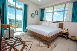 内罗毕Skynest Residences by CityBlue, Nairobi的一间卧室配有一张带蓝色窗帘和窗户的床。