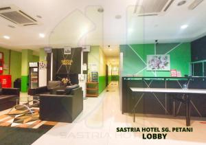 双溪大年Sastria Hotel Sungai Petani的客房设有桌子、沙发和书桌。