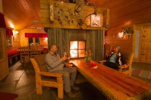 埃农泰基厄赫丹马耶特罗酒店的两人坐在小屋的木桌旁