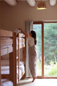 苏维里Agotzenea - Alojamiento con encanto en un entorno rural的一位妇女站在带双层床的房间
