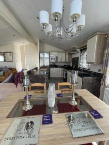 新罗姆尼Romney Lodge的厨房以及带两张盘子桌子的客厅。