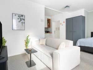 林茨limehome Linz Friedrichstraße的客厅配有白色的沙发和床。