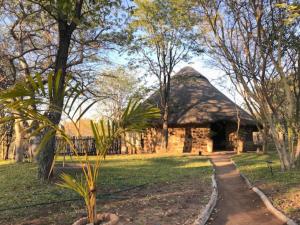 维多利亚瀑布Bungalow 4 on this world renowned Eco site 40 minutes from Vic Falls Fully catered stay - 1988的公园内茅草屋顶的建筑