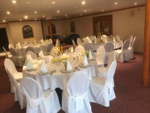 石勒苏益格霍亨索伦酒店的宴会厅配有白色的桌子和白色的椅子