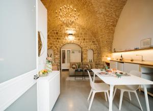 萨法德Azamra Inn Tzfat的厨房以及带白色桌椅的起居室。