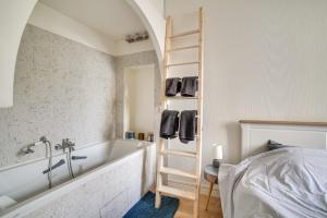塞纳河畔伊夫里Appartement charmant entièrement équipé的带浴缸和梯子的浴室