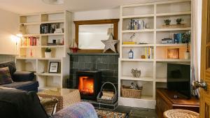 塔伯特Old Pier Cottage Tarbert的客厅设有壁炉和电视。