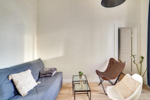 塞纳河畔伊夫里Appartement charmant entièrement équipé的客厅配有蓝色的沙发和两把椅子