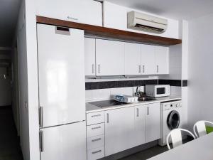 瓦伦西亚Flats Friends Tetuan的白色的厨房配有白色橱柜和冰箱。