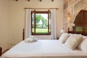 圣玛加利达Alcudiola的卧室配有一张大白色床和窗户