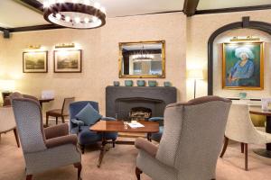 索尔兹伯里贝斯维斯特红狮酒店的客厅设有壁炉、椅子和桌子
