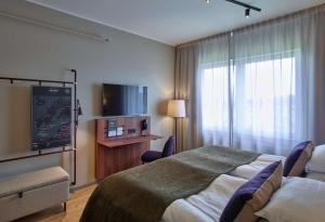 吕勒奥吕勒奥斯堪迪克酒店的配有一张床和一台平面电视的酒店客房