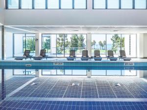 吉朗吉朗诺富特酒店的游泳池里摆放着一排椅子