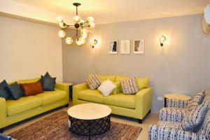 阿可贺巴Amwaj Resort For Families Only的客厅配有两张黄色的沙发和一张桌子
