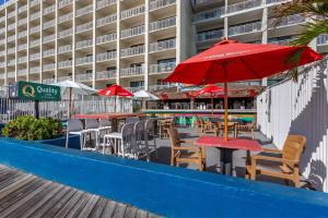 大洋城波德瓦克品质酒店的大楼里一排带红伞的桌椅