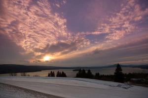 兰奇利Rangeley Lake Resort a Ramada by Wyndham的天空中阳光下白雪 ⁇ 的日落