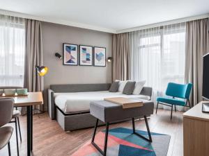 叙雷纳Aparthotel Adagio Paris Suresnes Longchamp的酒店客房,配有床和沙发