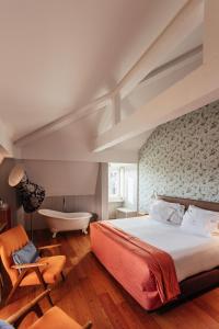 里斯本里斯本卡尔莫酒店的一间卧室设有一张大床和一个浴缸