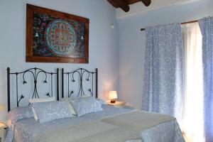 伊斯坦哈拉雷斯乡村酒店的一间卧室配有一张带蓝色床单的床和一扇窗户。