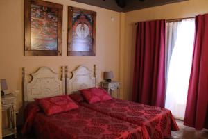 伊斯坦哈拉雷斯乡村酒店的一间卧室配有一张带红色床单的床和一扇窗户。