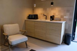 斯塔普霍斯特Bed & Wijn - Suite 1的厨房配有椅子和带微波炉的柜台。