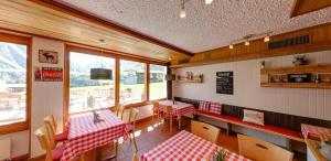 迪森蒂斯Catrina Lodge的餐厅设有红色和白色的桌椅