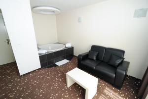 克尔什科克尔什科城市酒店的一间设有黑色皮椅和浴缸的等候室