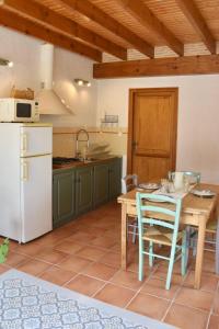 Montignac-ToupinerieUne pause nature chez Marion et Cédric的厨房配有桌子和白色冰箱。