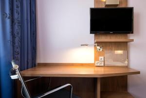 腓特烈港腓特烈港智选假日酒店的客房设有一张桌子、一台电视和一把椅子