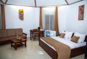 BanaLa Vallée de Bana的酒店客房设有一张大床和一张沙发。