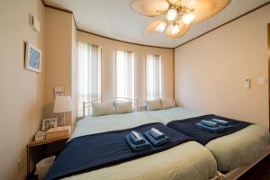 恩纳ペンション ラナカイハウス沖縄的一间卧室配有一张大床,上面有两条蓝色的毛巾