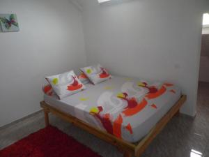 大博格IMMEUBLE NEBOT的一张带白色床单和红色及白色枕头的床