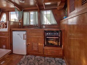 蒙特卡罗Monte-Carlo for boat lovers的厨房配有木制橱柜、炉灶和冰箱。