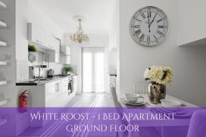 格雷夫森德The Roost Group - Stylish Apartments的白色的客房设有一张桌子,墙上挂着一个时钟