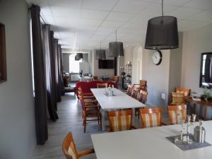 JöhstadtDie Alte Bäckerei的用餐室配有白色的桌子和木椅