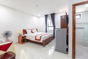 岘港Bao Ngoc Hotel & Apt的一间卧室配有一张床和一台电视。