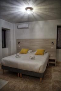 San-Gavino-di-CarbiniA PIANARELLA的一间卧室配有一张带黄色枕头的大床