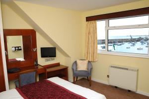 格雷海豚酒店的配有一张床、一张书桌和一扇窗户的酒店客房