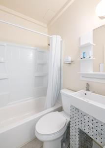 洛杉矶好莱坞历史酒店的白色的浴室设有卫生间和浴缸。