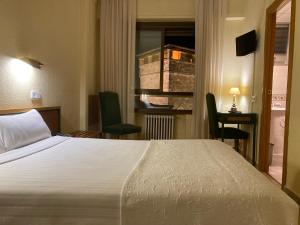 萨拉曼卡康达尔酒店的配有一张床、一张书桌和一扇窗户的酒店客房